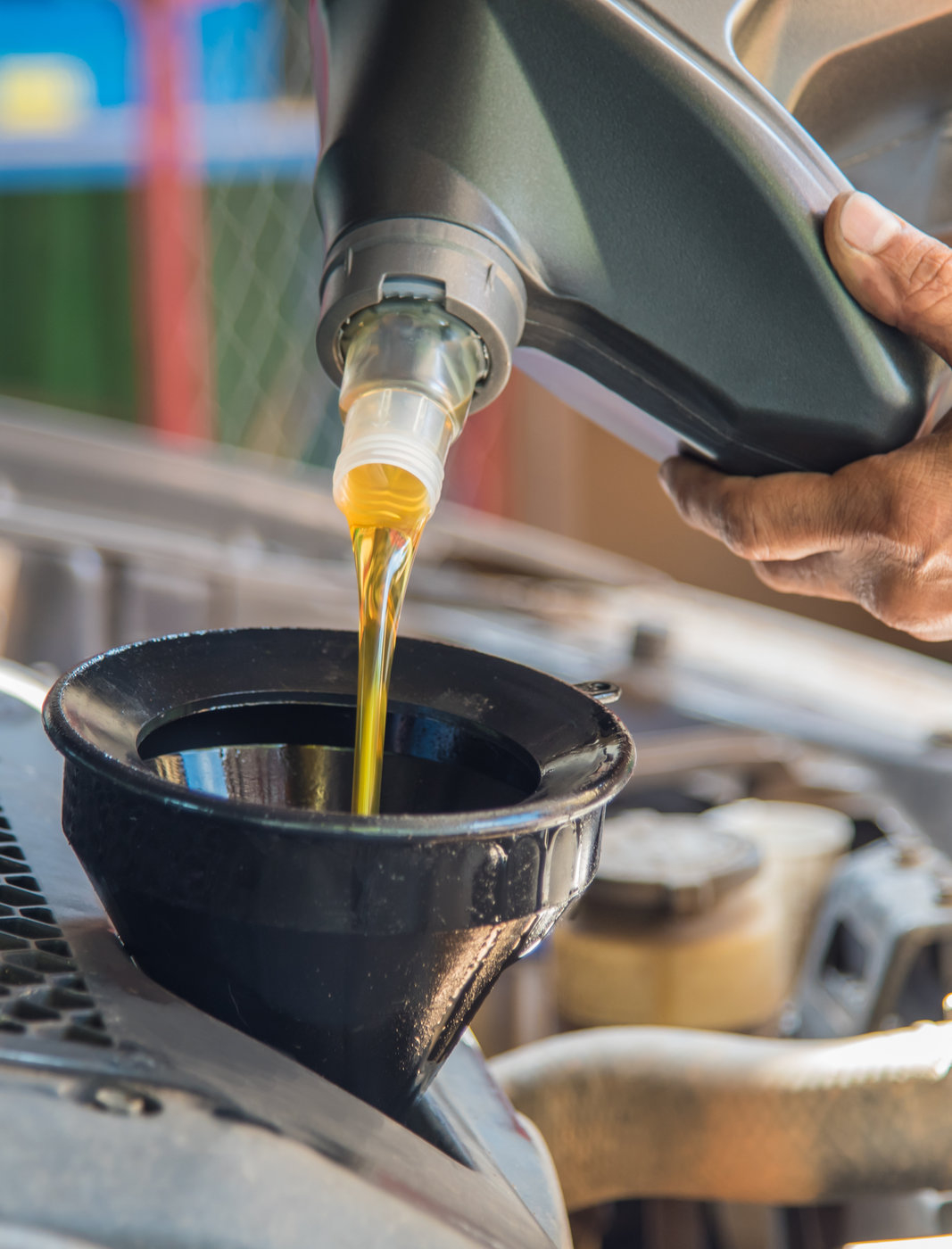 Mechanic pouring new oil into a car engine - Car Servicing Batley
