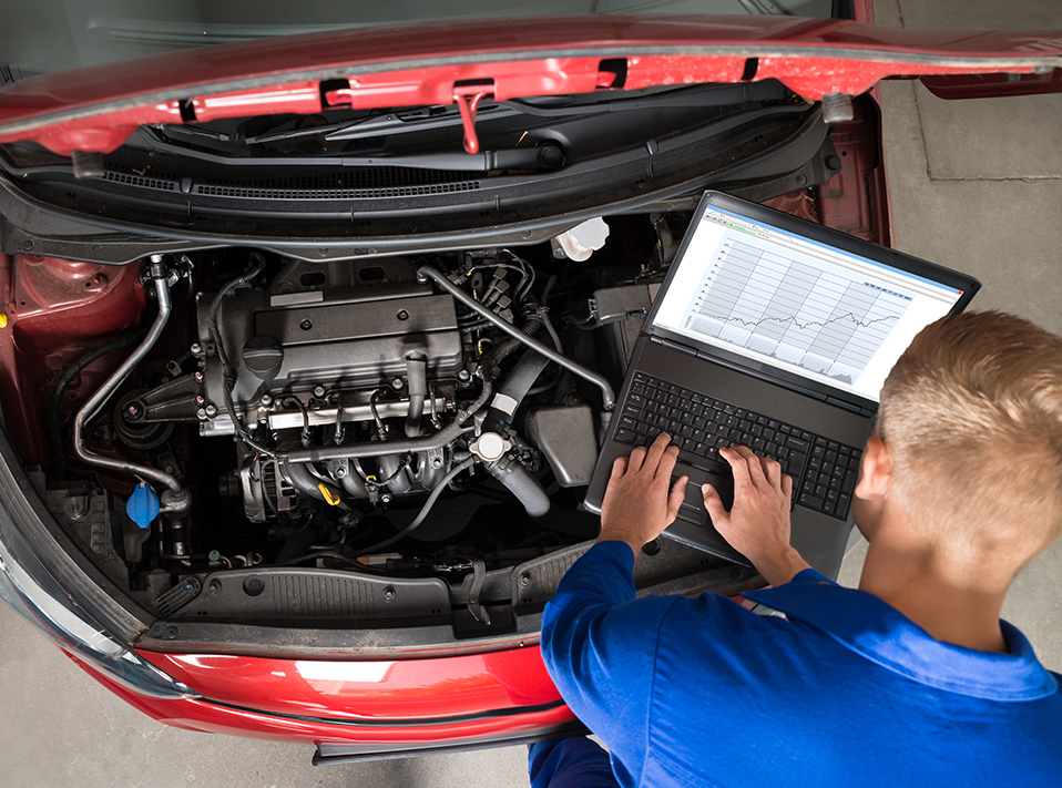 Mechanic checking a vehicles engine using modern technology to help diagnose a vehicle - Car Diagnostics Batley